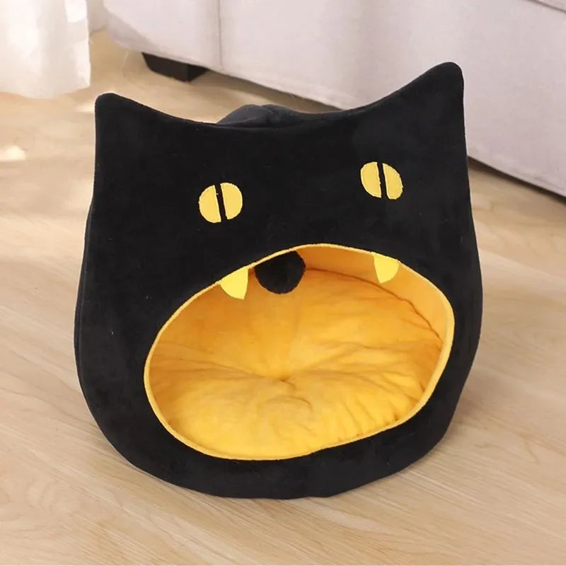 Grey cat-shaped enclosed pet bed with a round opening, sitting on a wooden floor.