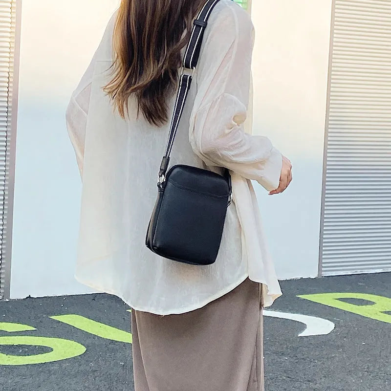 Solid colour small PU crossbody shoulder bag for mobile phones on a strap.