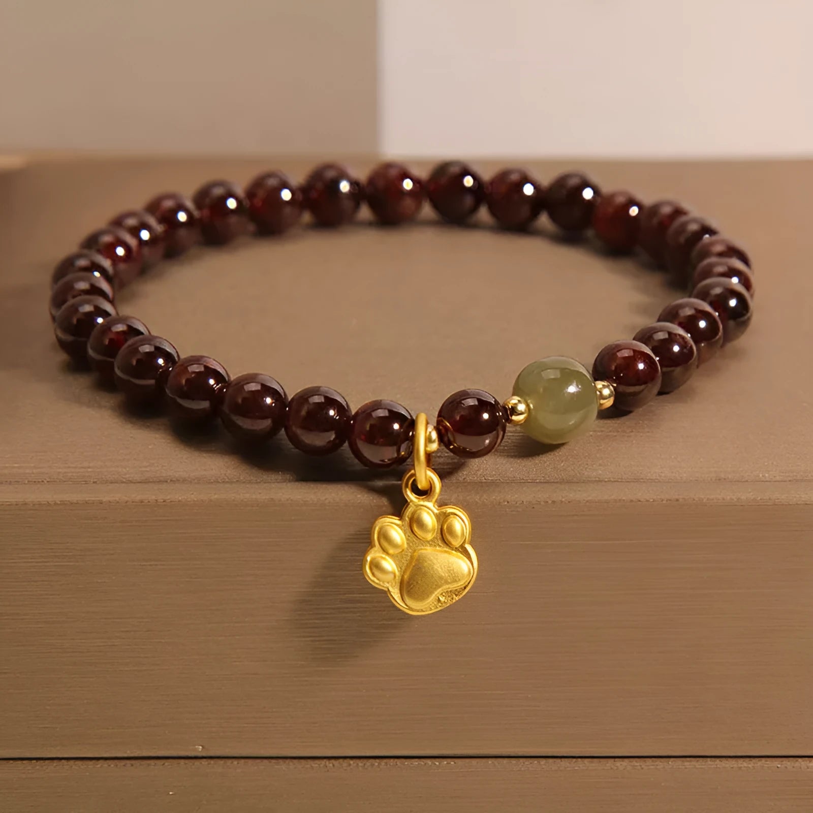 Women's Cat's Paw Garnet crystal bracelet on wrist, original design.