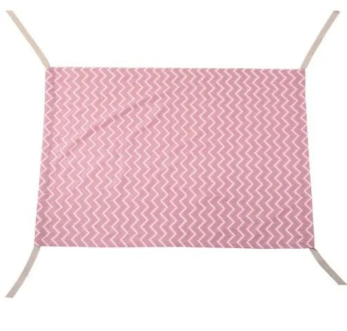 Portable crushed velour baby hammock attached to a white crib, shown in a pink colour.