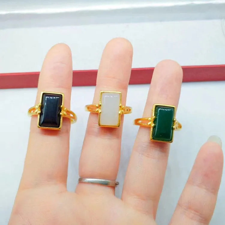 Adjustable brass gold-plated ring with a green gemstone inlay, showing national style design