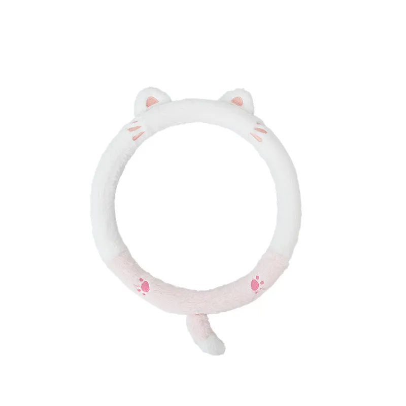 Plush winter steering wheel cover with embroidered bear design, shown on a car steering wheel.