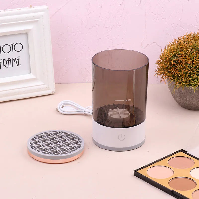 Grey and white portable electric makeup brush cleaner with USB cable.