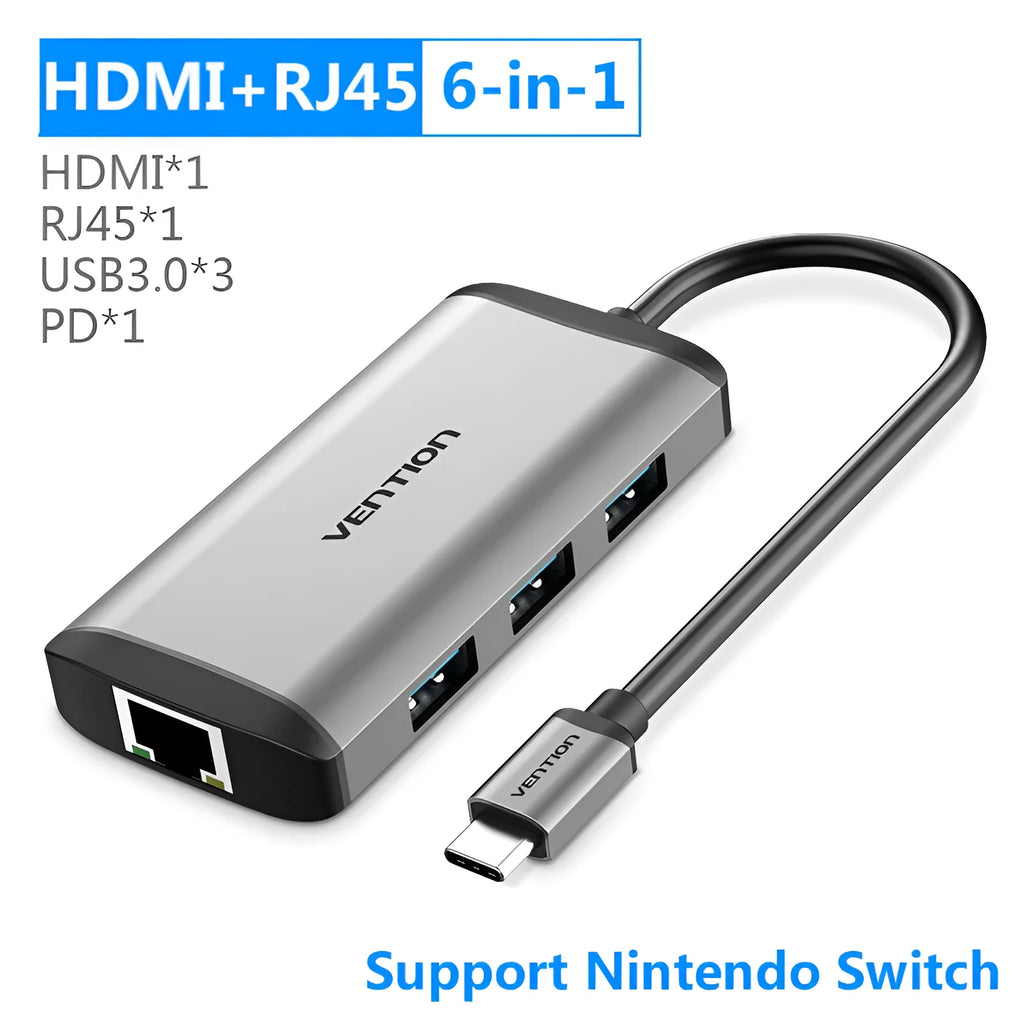 Deep grey USB-C to HDMI, USB, Ethernet, and card reader multi-port adapter hub on a desk.