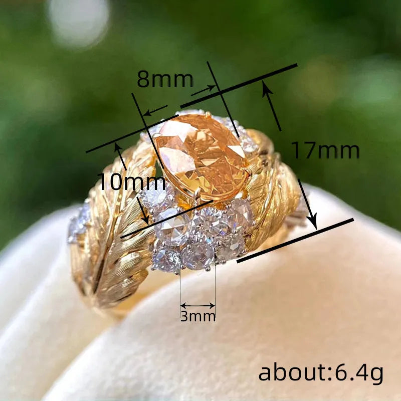 Gold-colour copper feather ring with a geometric design and a yellow zircon stone.