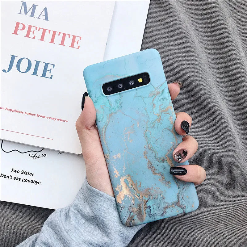 Samsung Galaxy phone case with a white and grey marble pattern on a black polycarbonate back cover.