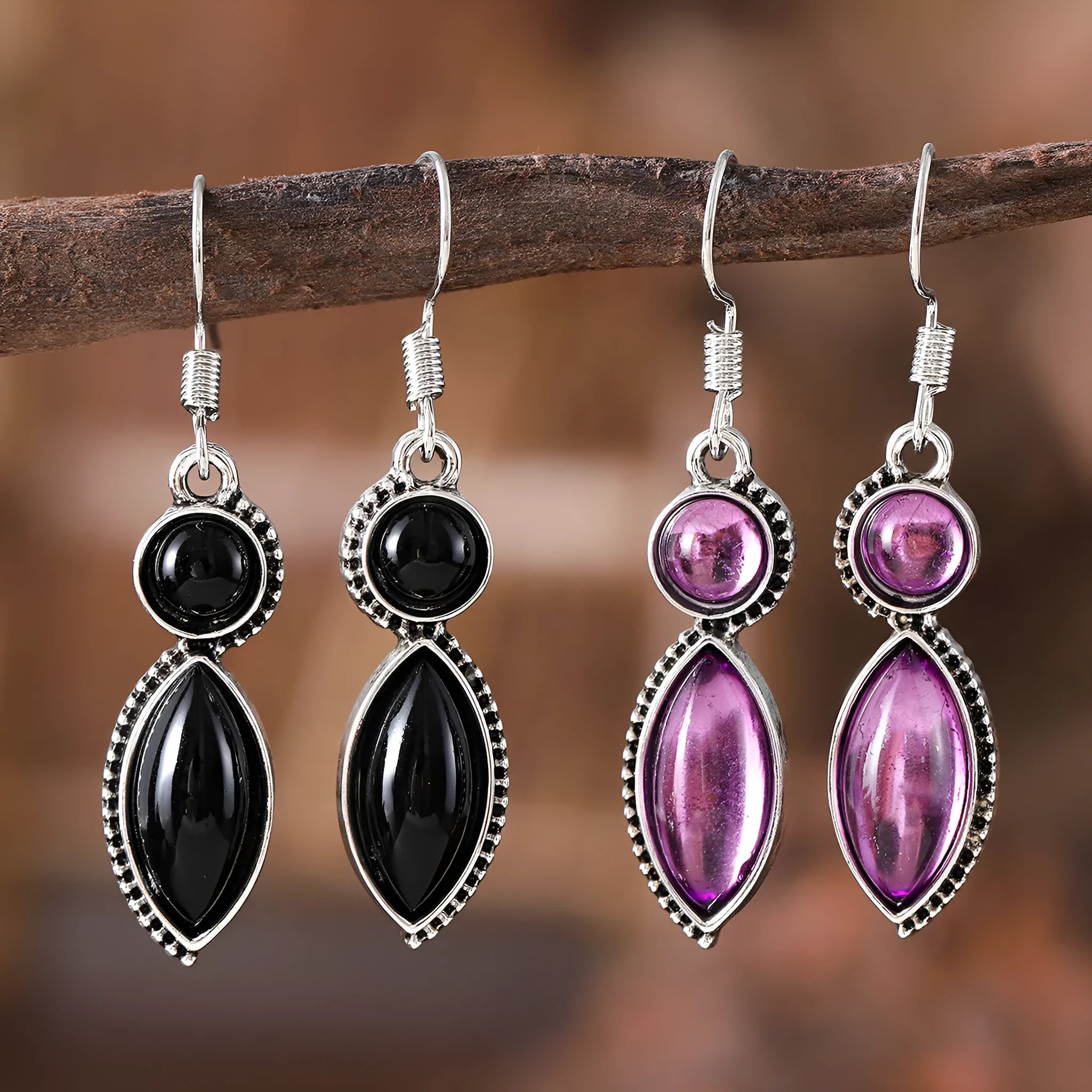 Vintage silver-tone geometric drop earrings with round purple and black stones on a grey background.