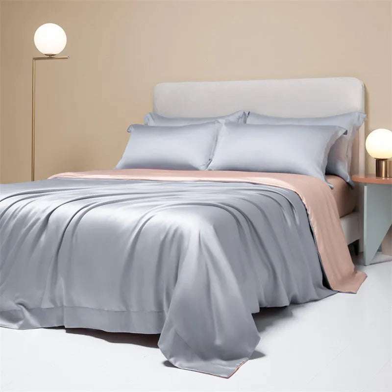 A neatly made bed with a Lenzing Tencel duvet cover and pillowcases in a soft grey colour.