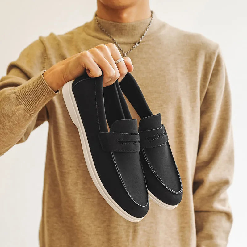 Men's beige suede British style casual slip-on shoes with a round toe and low flat heel on a rubber sole.