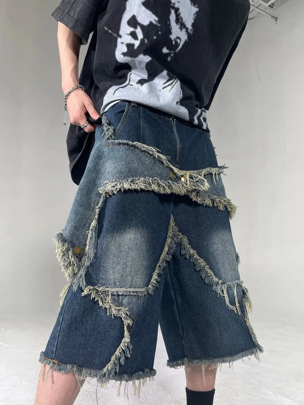 Blue denim shorts with frayed five-pointed star design and loose fit construction