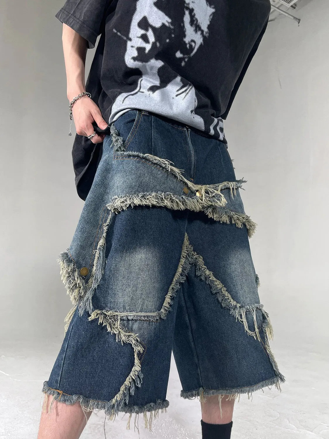 Blue denim shorts with frayed five-pointed star design and loose fit construction