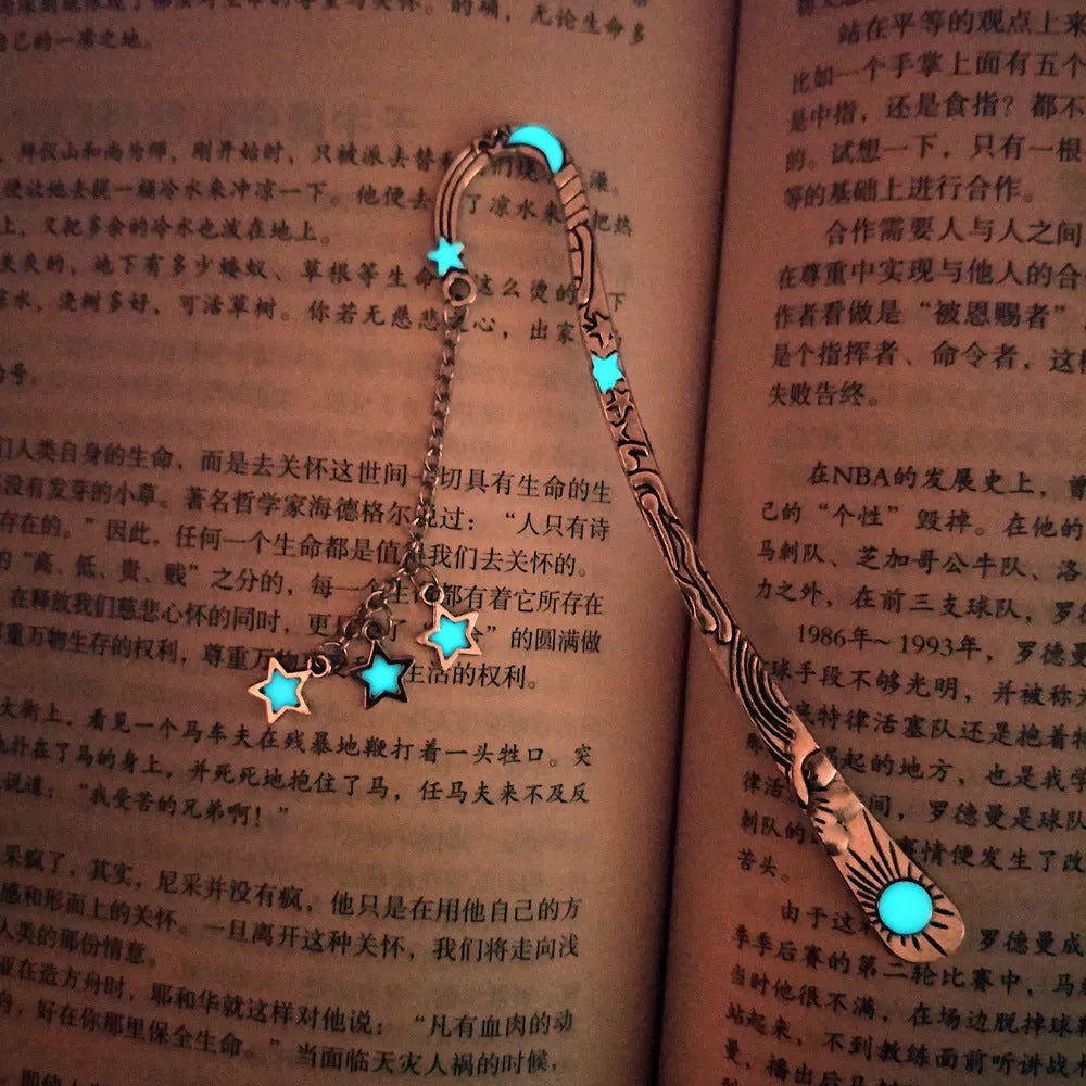 Metal bookmark with glowing five-pointed star and celestial sun moon stars design