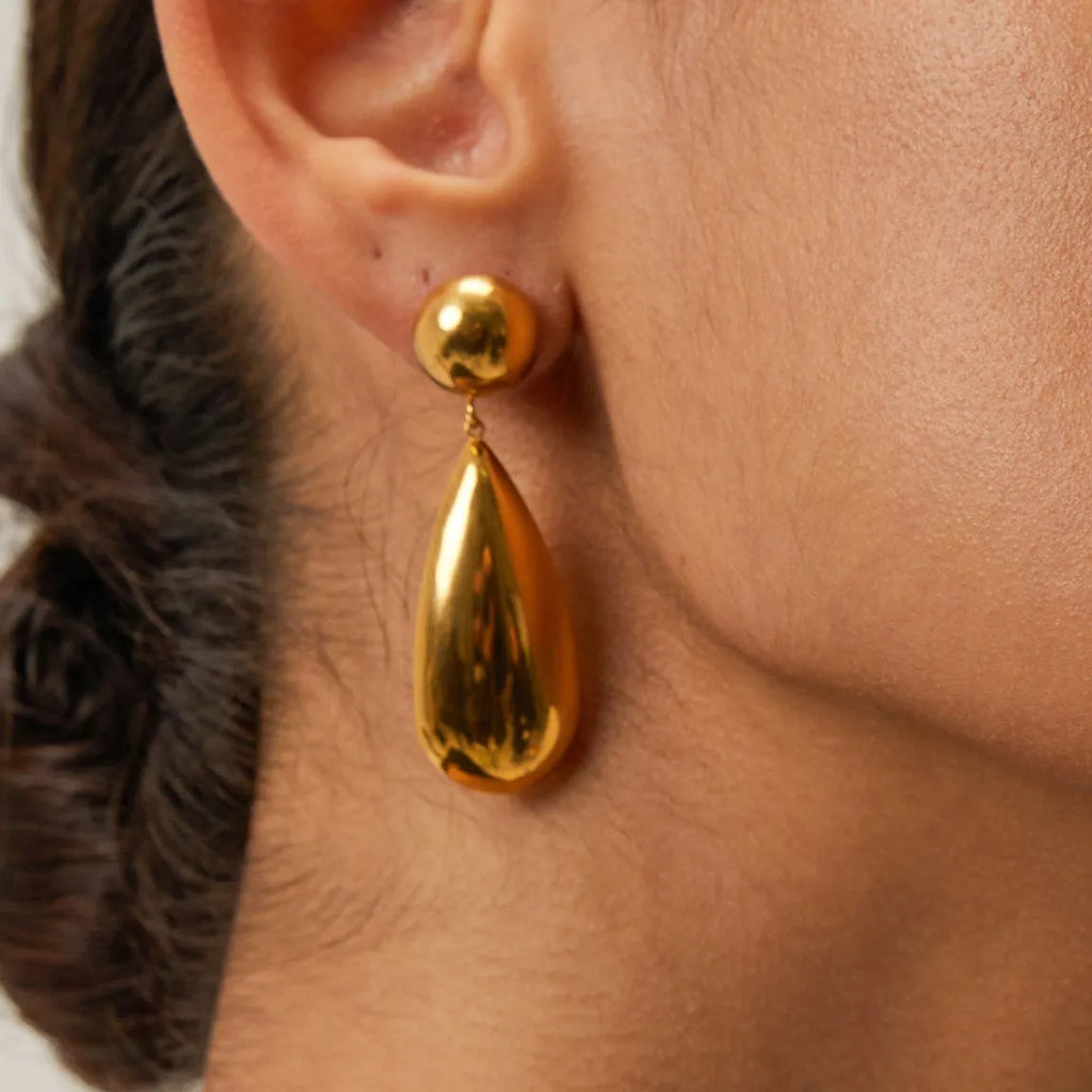Gold-colour stainless steel pendant earrings with geometric hemisphere and water drop design.