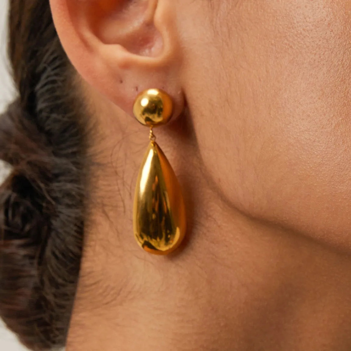 Gold-colour stainless steel pendant earrings with geometric hemisphere and water drop design.
