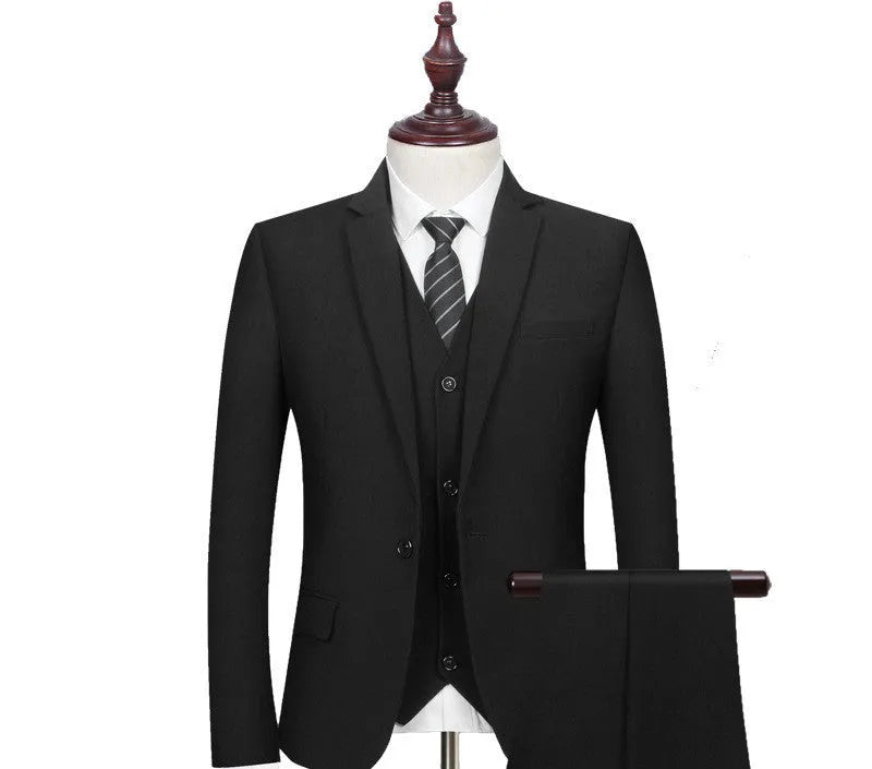 New men's slim fit black business suit set with 1-button jacket, waistcoat, shirt, and trousers on a hanger.