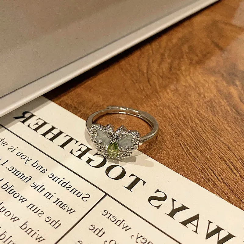A copper women's ring with a butterfly design and a unique dripping oil textured finish.