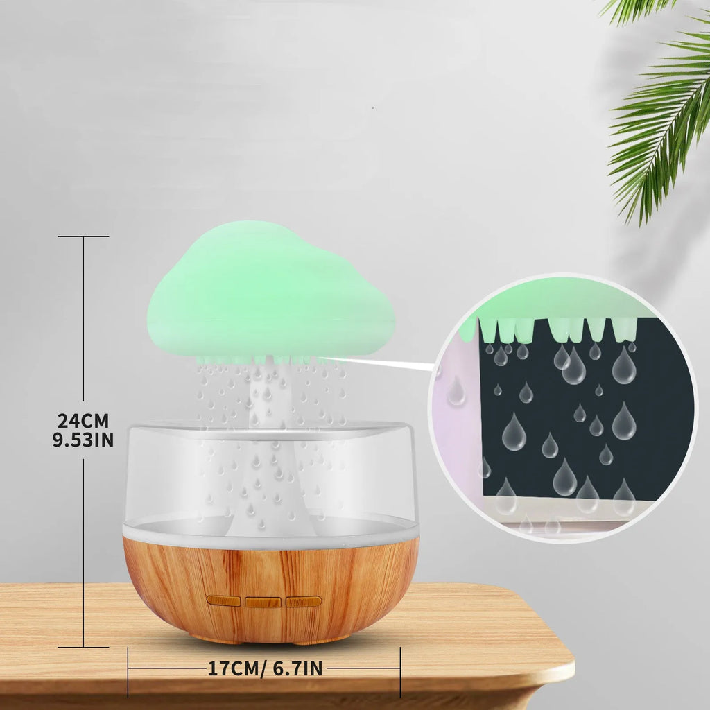 White cloud-shaped humidifier and essential oil diffuser with coloured mood light on.