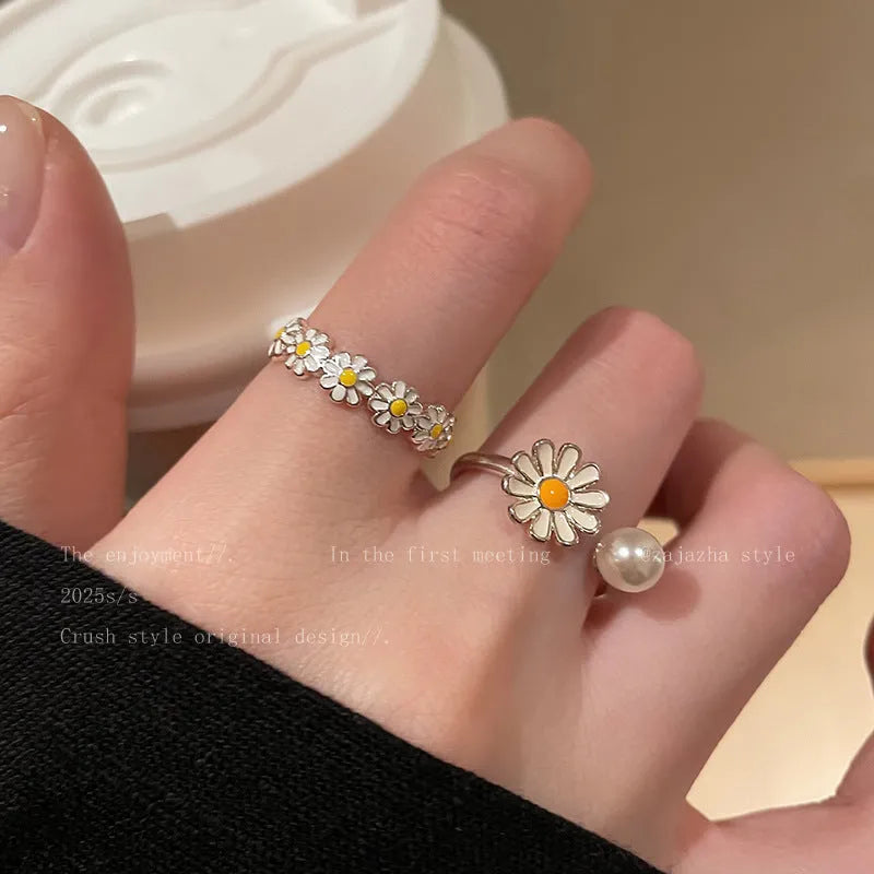 Women's adjustable copper ring with a little daisy and pearl decoration on a white background.