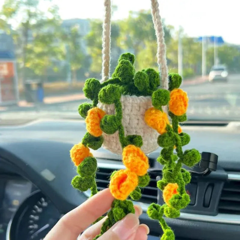 Green and white knitted wool car plant ornament hanging from a rope
