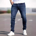Man wearing dark blue slim-fit skinny jeans with a medium-elastic waist and zipper fly.