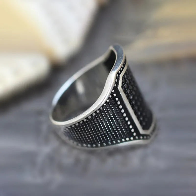 Matte black adjustable ring with a clear zircon stone and copper metal inlay detail on a plain background.