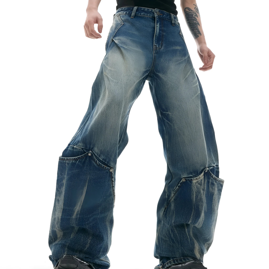Men's verdant blue loose fit jeans showing curved knife pattern detail and vintage wash on a cotton blend fabric.
