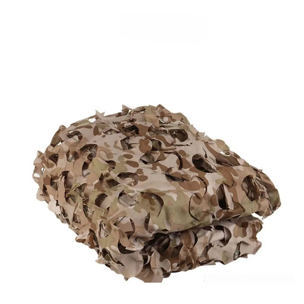 Green camouflage netting on a forest floor showing a multi-spot camouflage pattern.