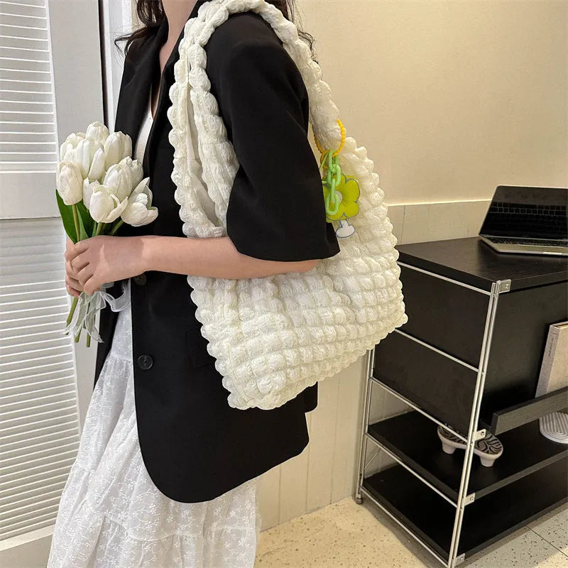 Women's pleated bubble shoulder bag with a floral pendant in soft polyester, shown in a vertical square shape.