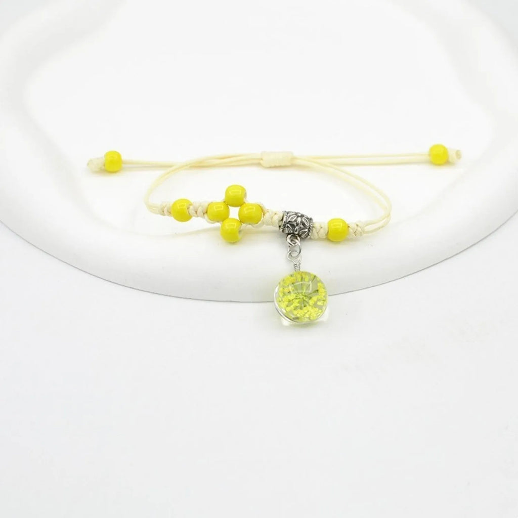 Close-up of a hand-woven glass bracelet with large 1.4cm beads containing real dried flowers.