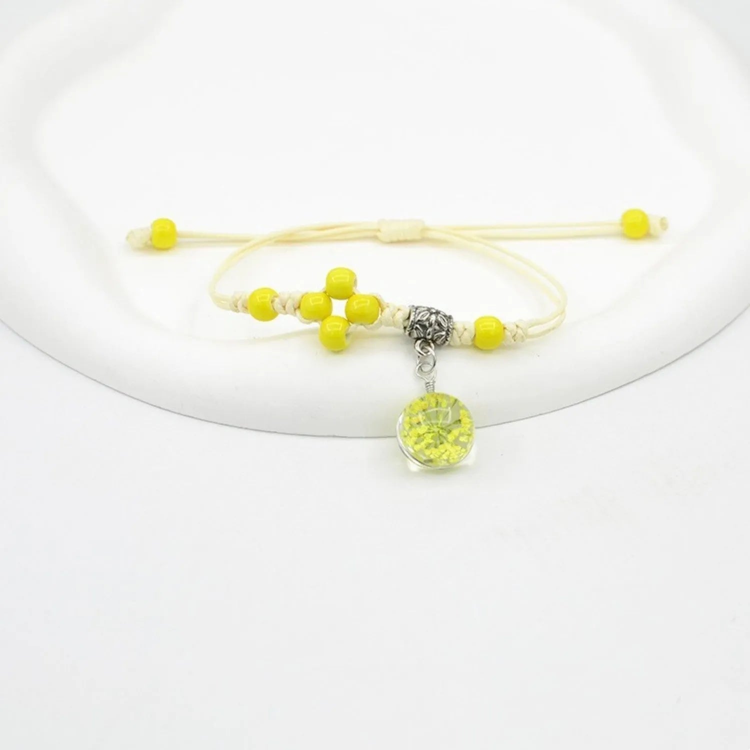 Close-up of a hand-woven glass bracelet with large 1.4cm beads containing real dried flowers.