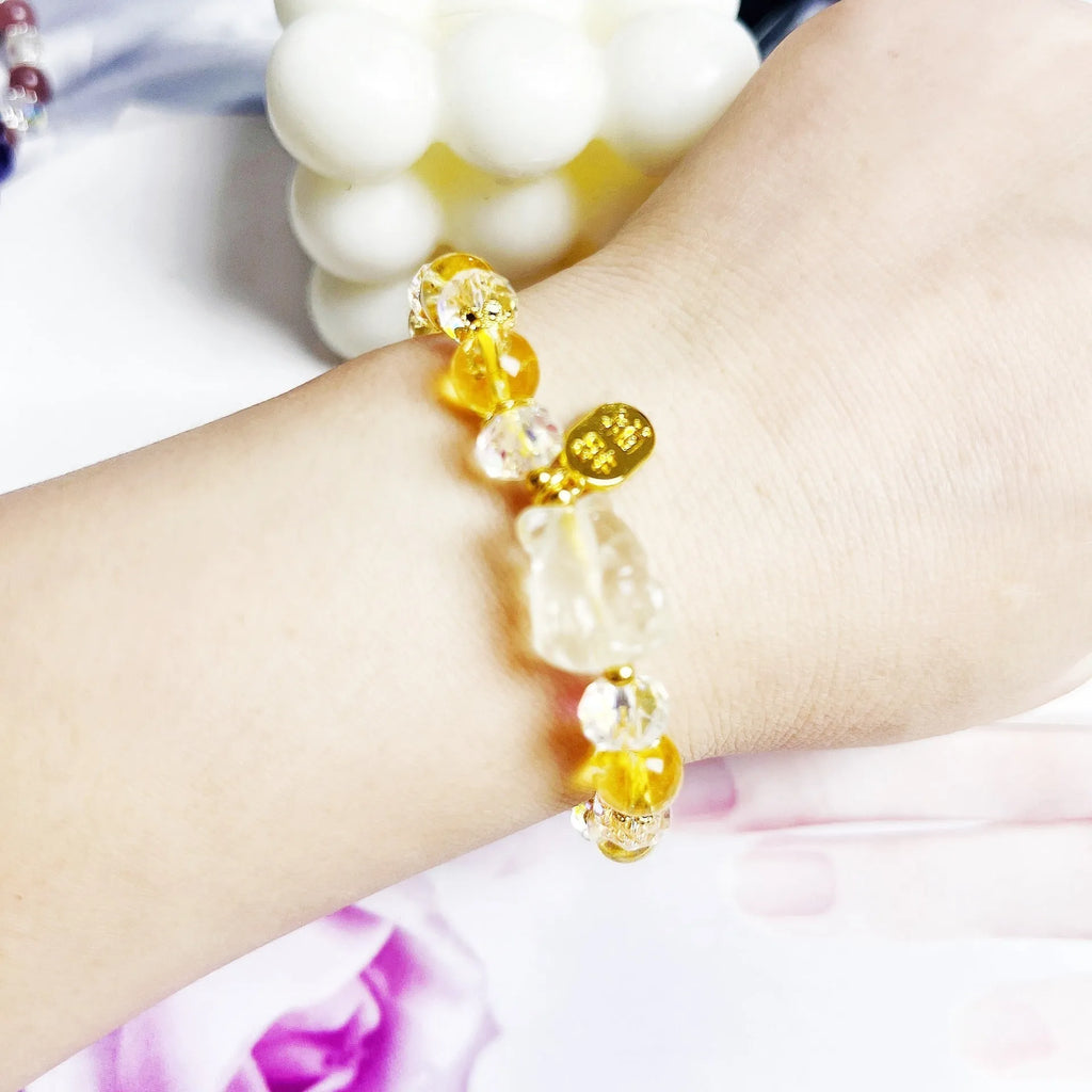 Handmade natural citrine crystal bracelet with detailed nine-tail fox design on a white background.