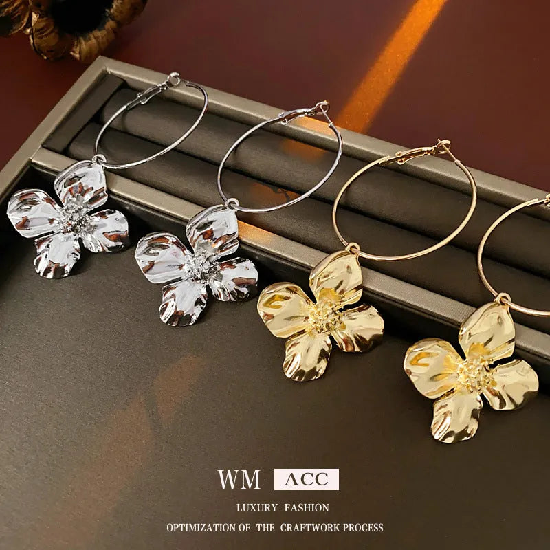 A pair of vintage-style floral drop earrings with geometric silver needle details, shown in a gold electroplated finish.
