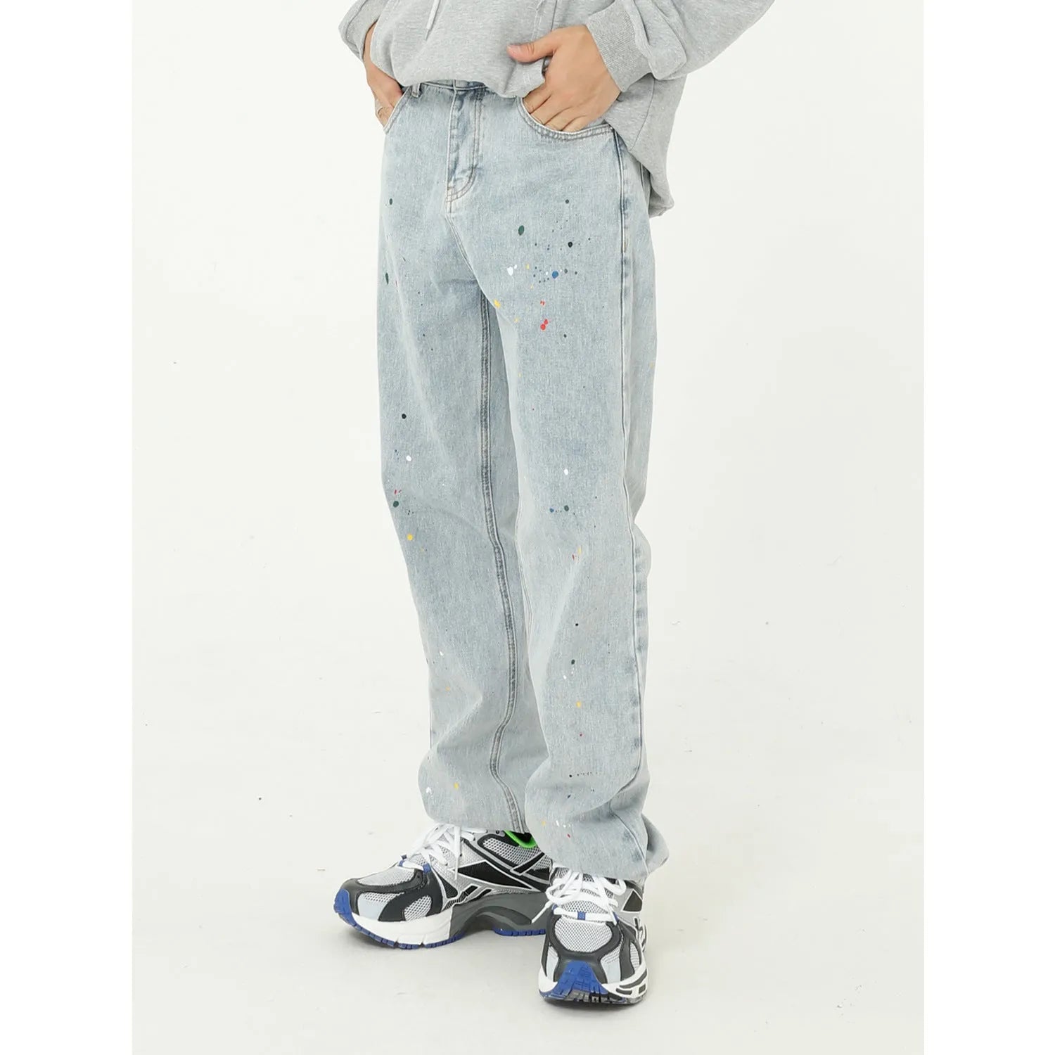 Light blue straight loose jeans with paint splash and washed finish, mid-waist zip fly, laid flat on neutral background