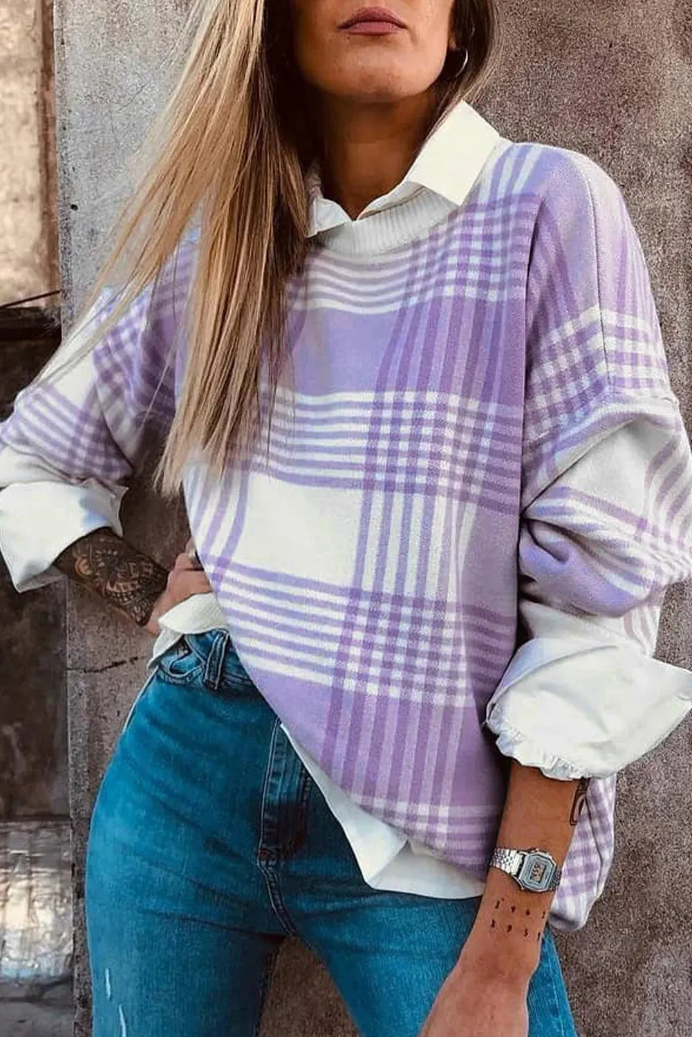 Lilac plaid print loose women's sweater with ribbed collar and cuffs on a hanger.