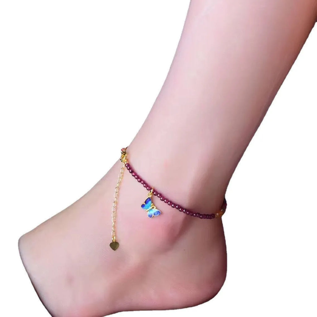 Close-up of a purple garnet anklet with a geometric design on a female ankle.