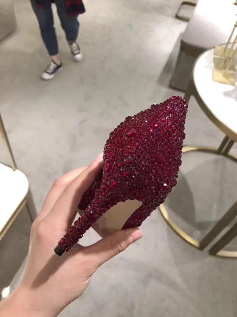 Women's gold high heels with pointed toe, rhinestone decoration, and a stiletto heel.