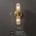 Modern double head wall lamp with a copper finish mounted on a light grey wall.
