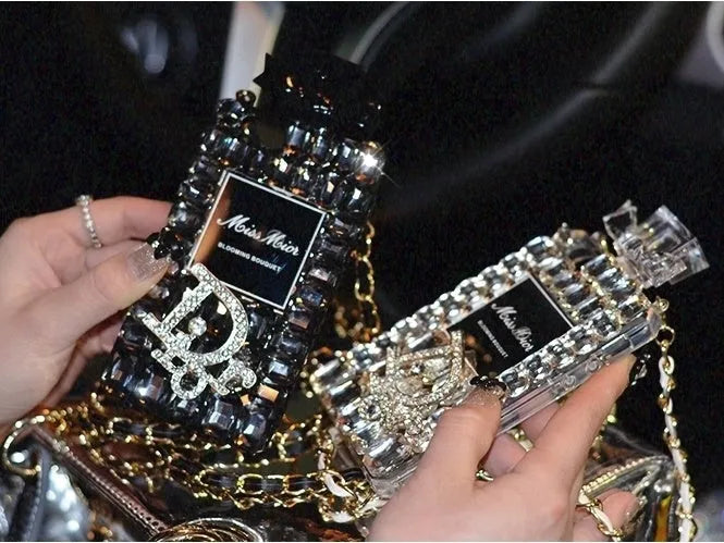 Perfume bottle bow design iPhone case with textured TPU silicone and a fixed metal chain, shown in black, gold, pink, and transparent.