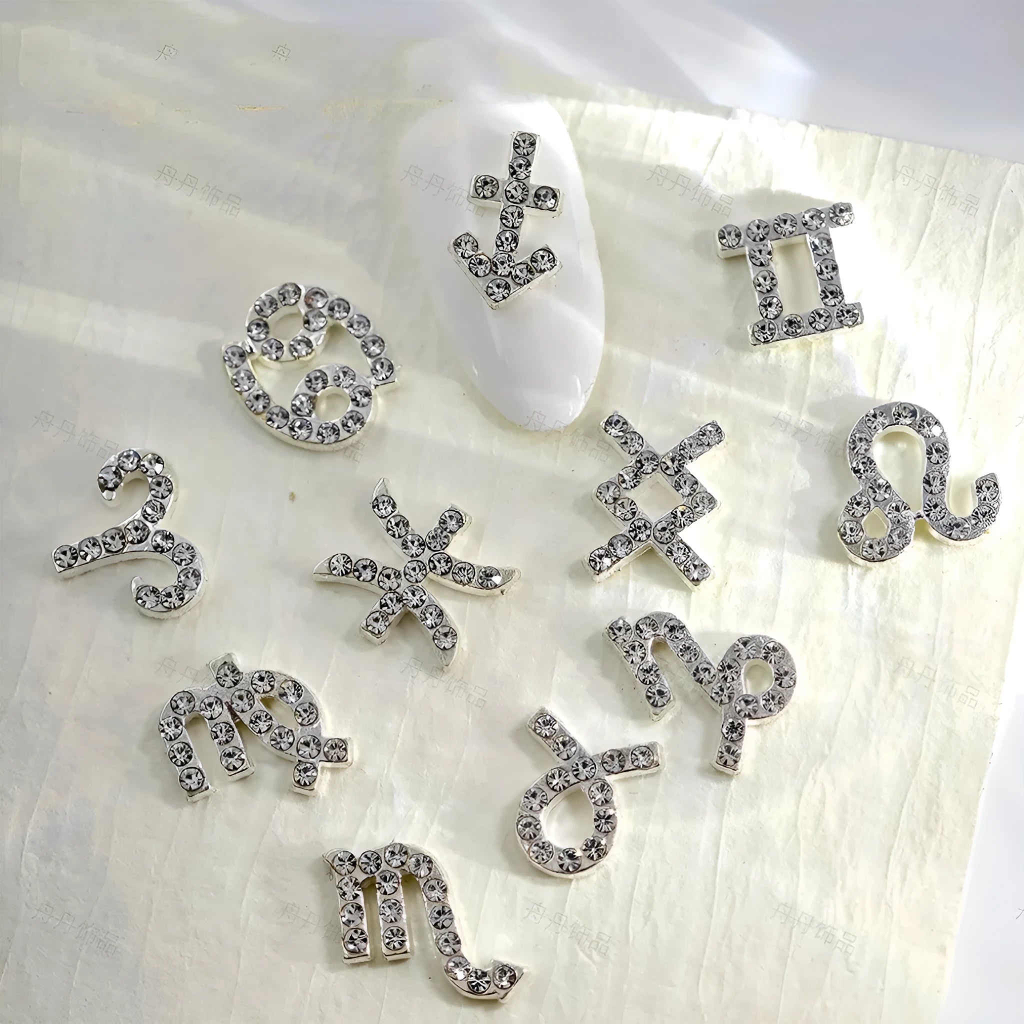 Twelve zodiac nail art accessories in alloy with diamond inlays, silver and gold finish, starry sky pattern.