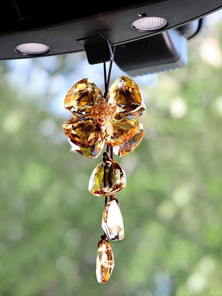 Crystal four leaf grass car pendant hanging, shown in different colour options including transparent and champagne.