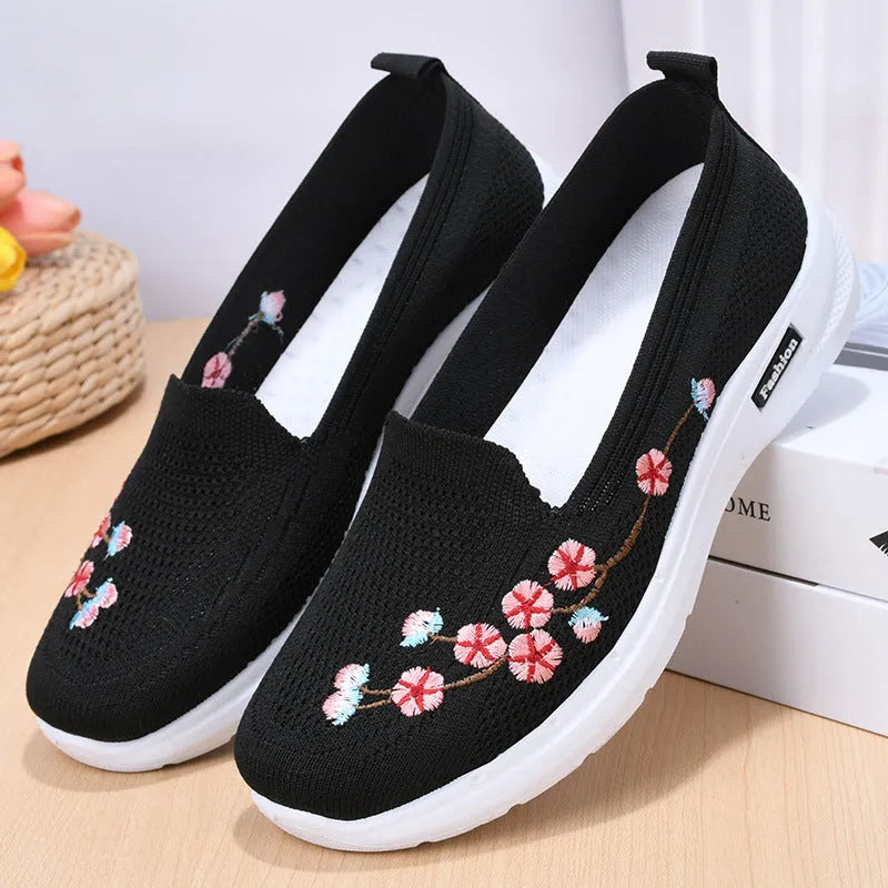 Women's black woven ballet pumps with floral embroidery and a flat anti-slip sole.