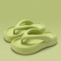 A pair of solid-colour thick-soled EVA flip-flops with a decorative bow on the thong strap.