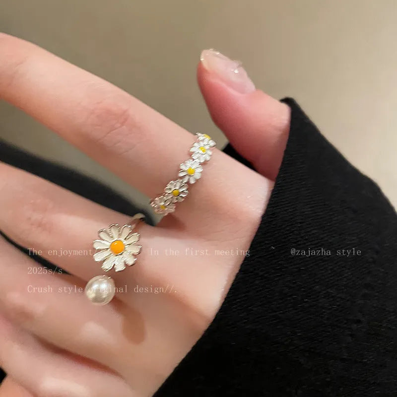 Women's adjustable copper ring with a little daisy and pearl decoration on a white background.