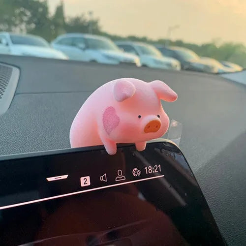 A cute cartoon pig resin figurine car decoration accessory on a dashboard.