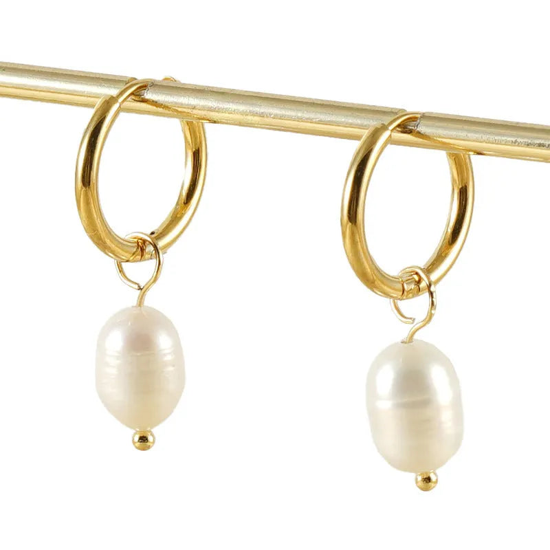 Gold geometric women's earrings with a pearl detail on a white background