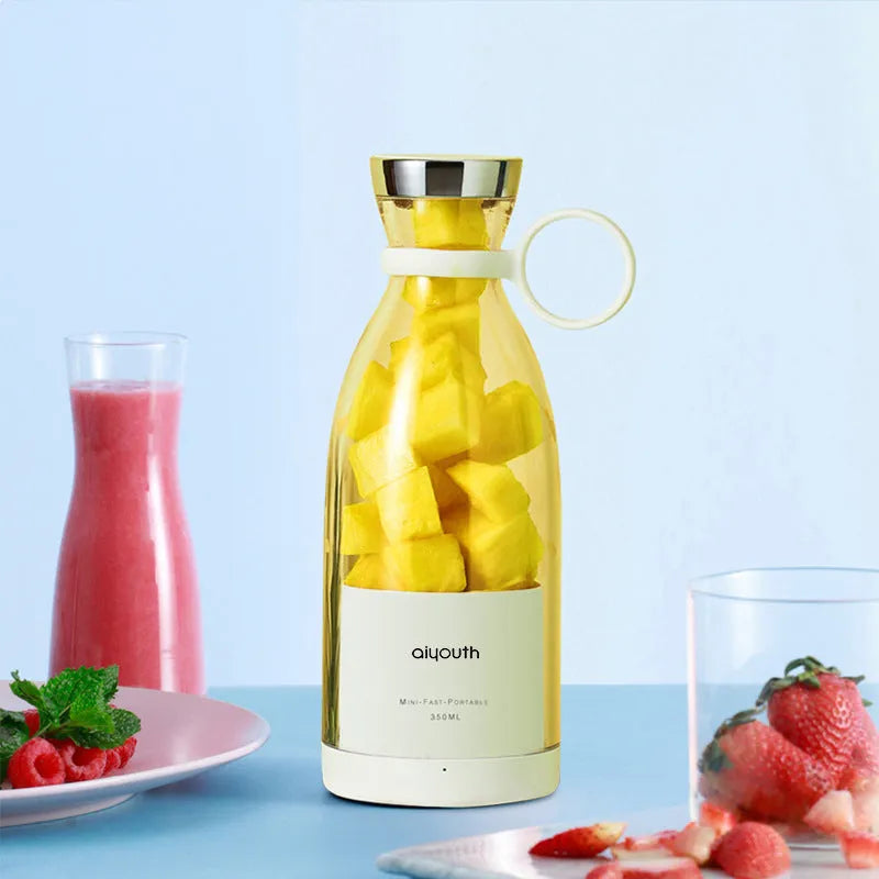 Pink and white handheld portable mini juicer with USB charging cable.