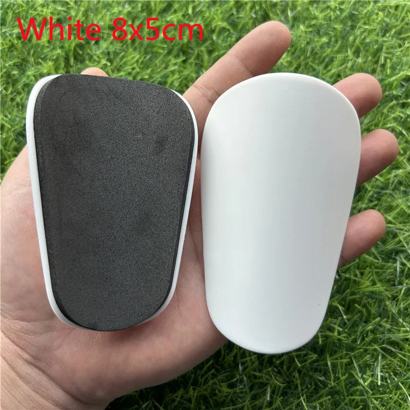 Extra small mini football shin guards in black and white, measuring 8x5cm