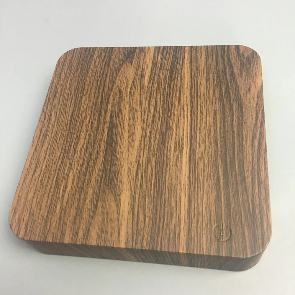Walnut-coloured magnetic levitation base with floating galaxy-patterned moon lamp illuminated in dark setting