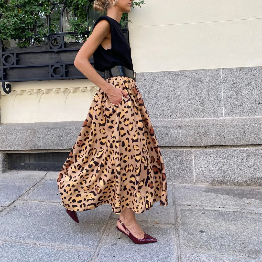Brown leopard print women's long A-line skirt with a wide flowing hem, shown on a hanger.