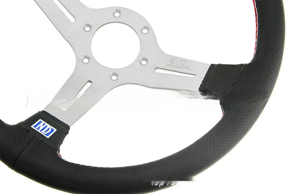 Black leather 14-inch steering wheel with deep middle concave grip and silver three-spoke skeleton.
